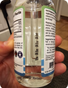 Hand holding a clear liquid magnesium supplement bottle, supplement health focus