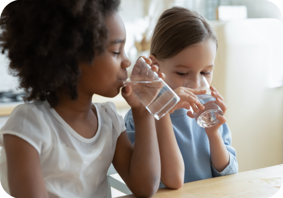 Children drinking water at a table, promoting supplements health and hydration