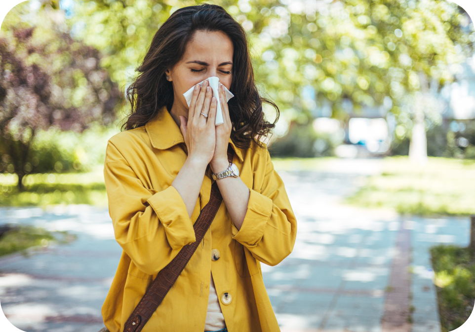Woman sneezing outdoors, symbolizing immune health and need for supplements