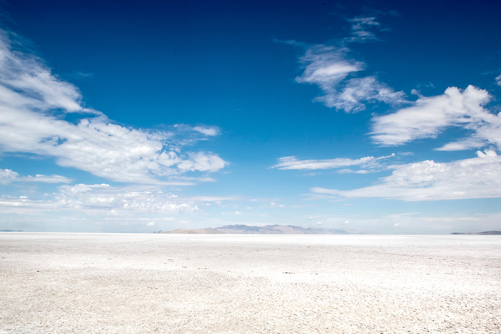Desert salt landscape with a clear blue sky and scattered clouds