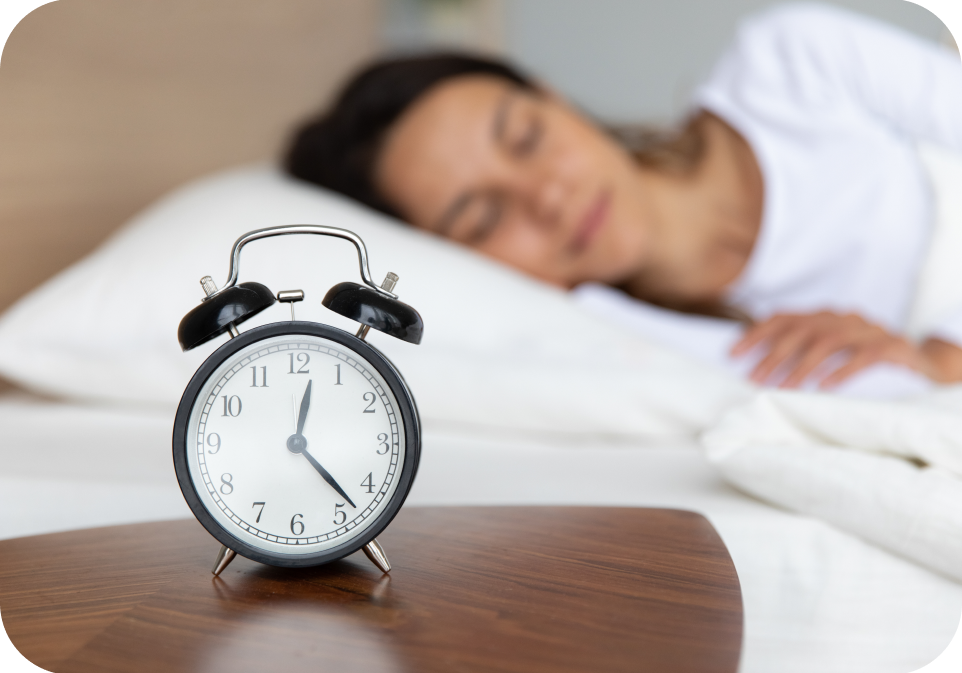 Woman sleeping in bed with alarm clock in foreground, supplements health concept