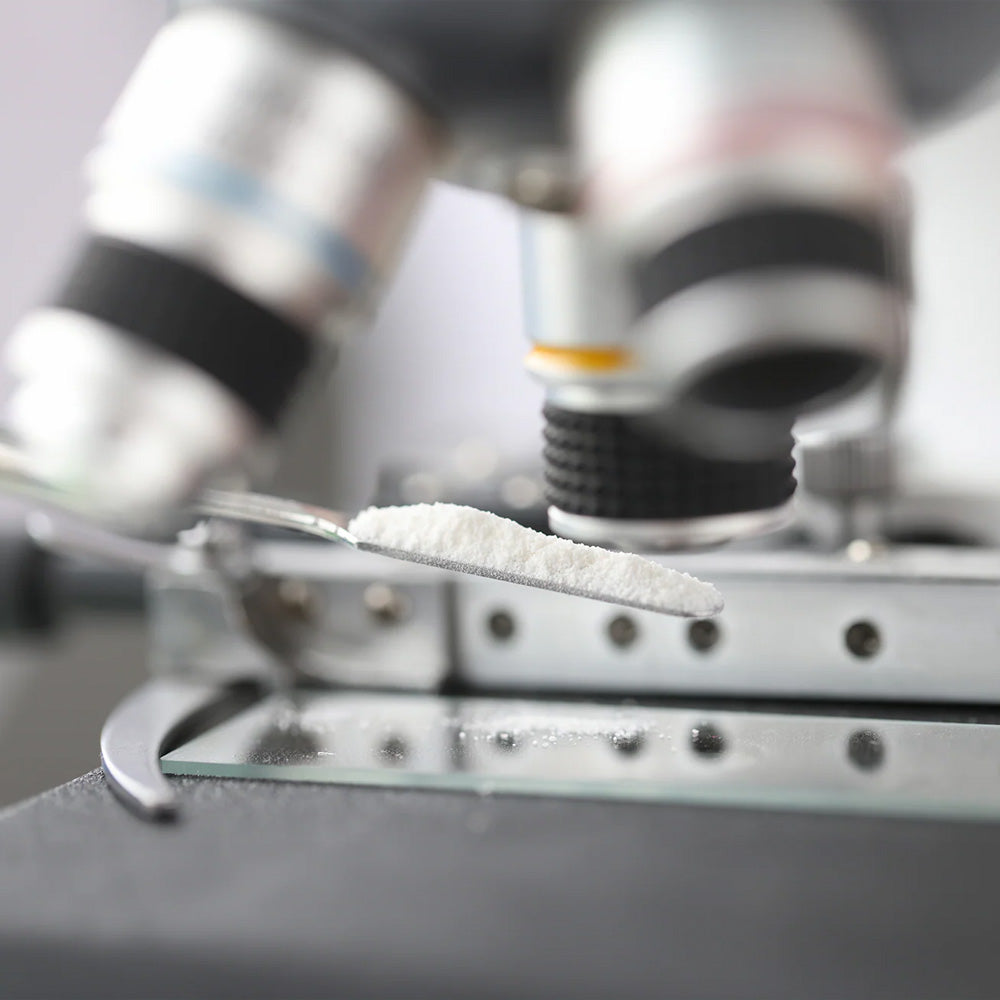 White supplement powder sample under microscope in health supplements lab